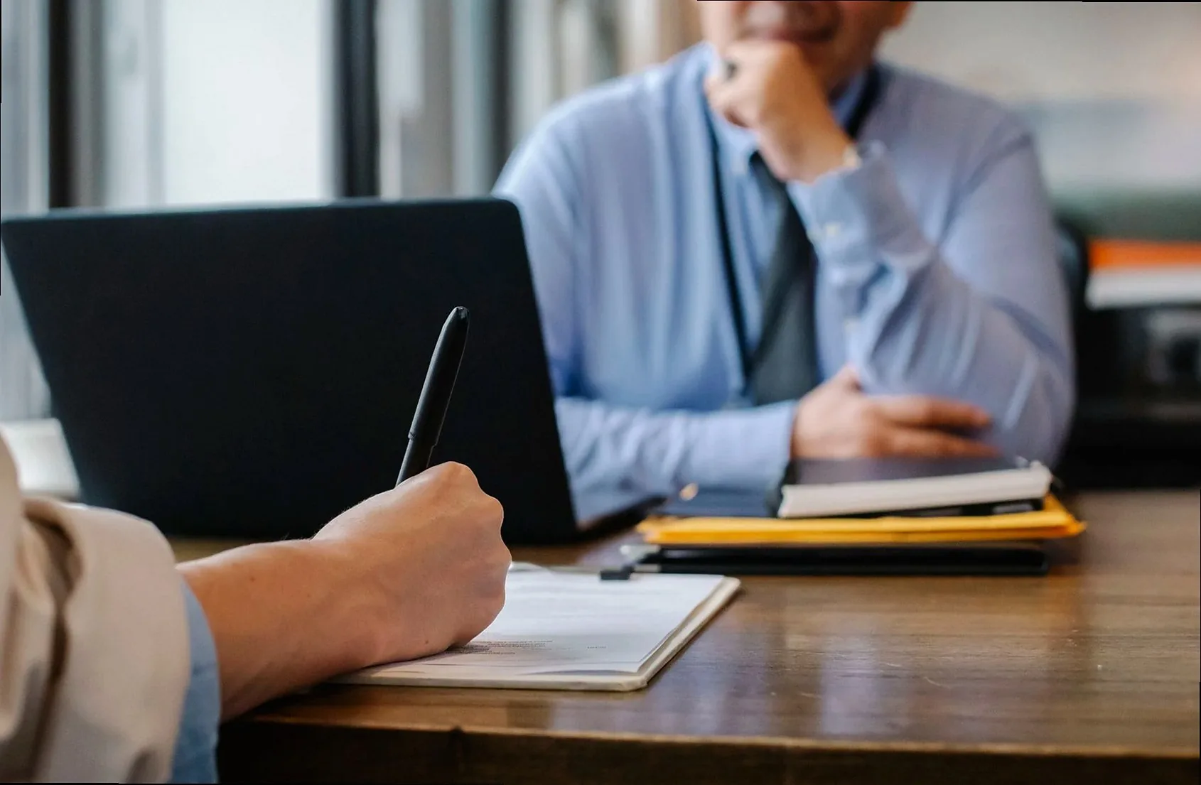 Crop anonymous female filling questionnaire when applying for job sitting in employer office